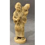A 19th/early 20th century Japanese ivory figure of a man with a child on his back,