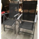 A pair of grey metal framed folding garden armchairs