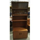 A G-Plan teak wall unit with two upper glazed doors enclosing two shelves over a two door base,