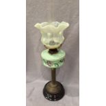 A brass and green floral patterned oil lamp with glass Nouveau style shade and funnel, 72cm high,