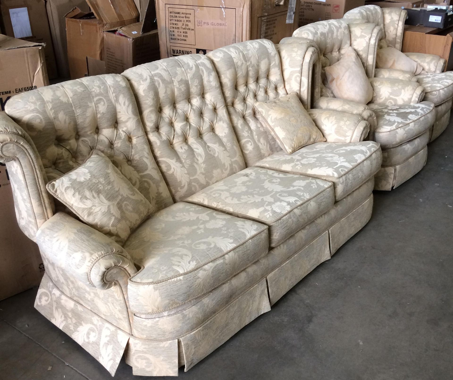 A beige and gold leaf patterned three piece suite comprising three seater settee and two armchairs