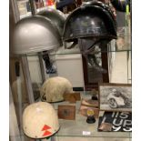 Three vintage motorcycle crash helmets (for display purposes only), two old number plates,