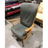 An Ercol light elm high back armchair with green patterned seat and back cushion [Please note - the