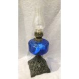 A metal and blue glass oil lamp with glass shade, the turner inscribed English Made Wick,