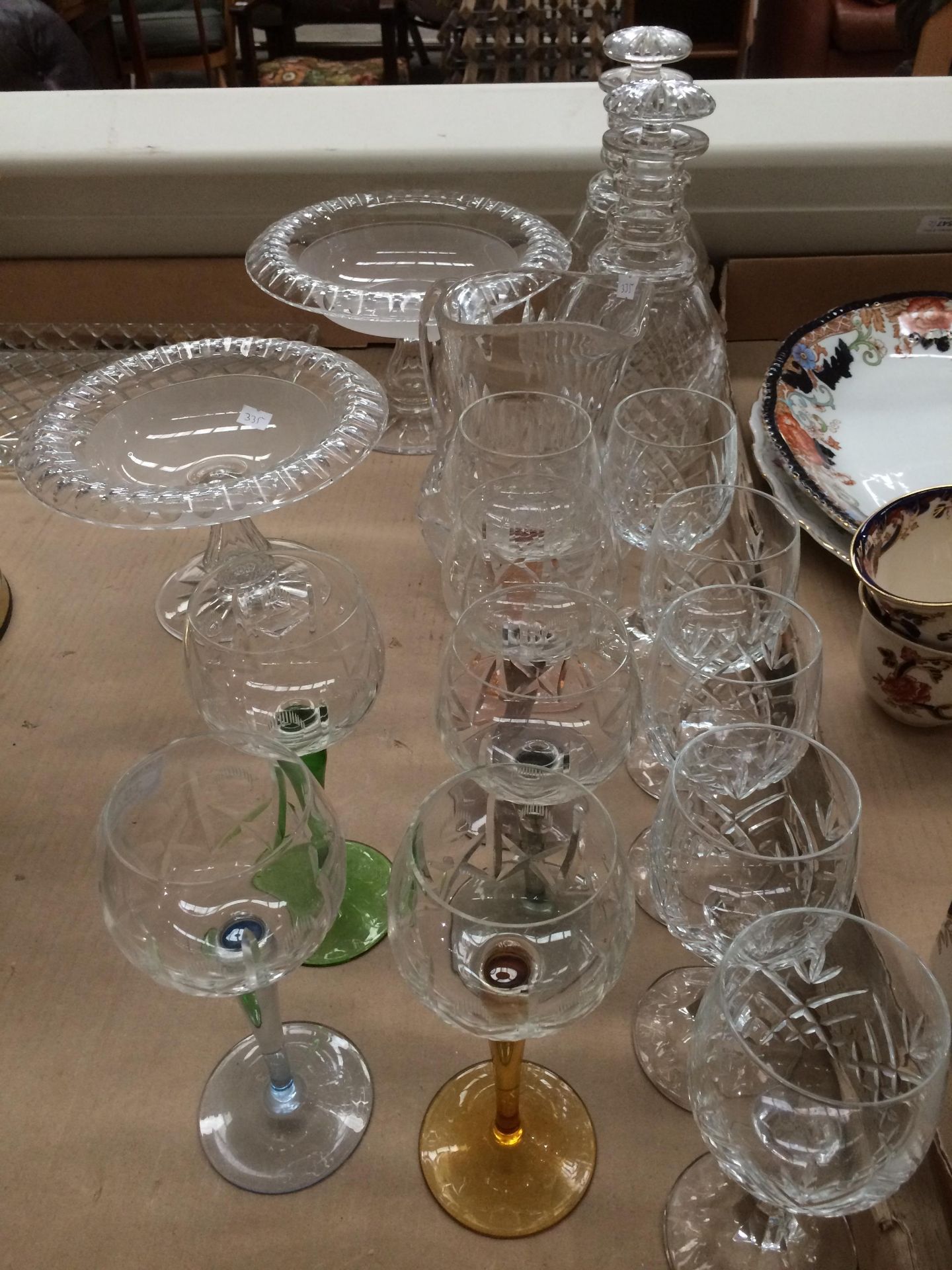 Six coloured stem wine glasses and five other wine glasses, two pedestal fruit bowls,