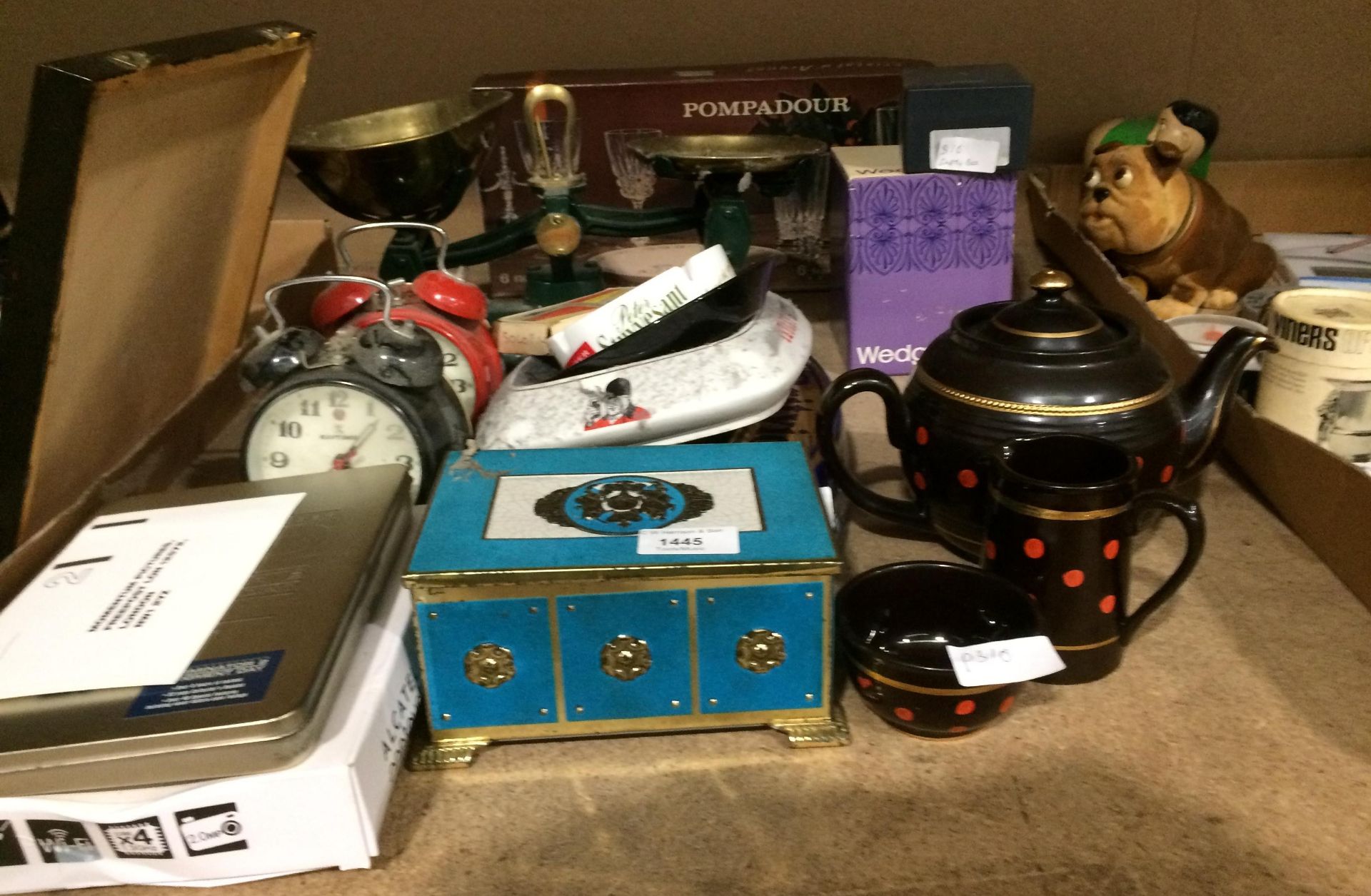 Contents to part of rack - old ashtrays, alarm clock, a pair of brass and green metal scales, etc.