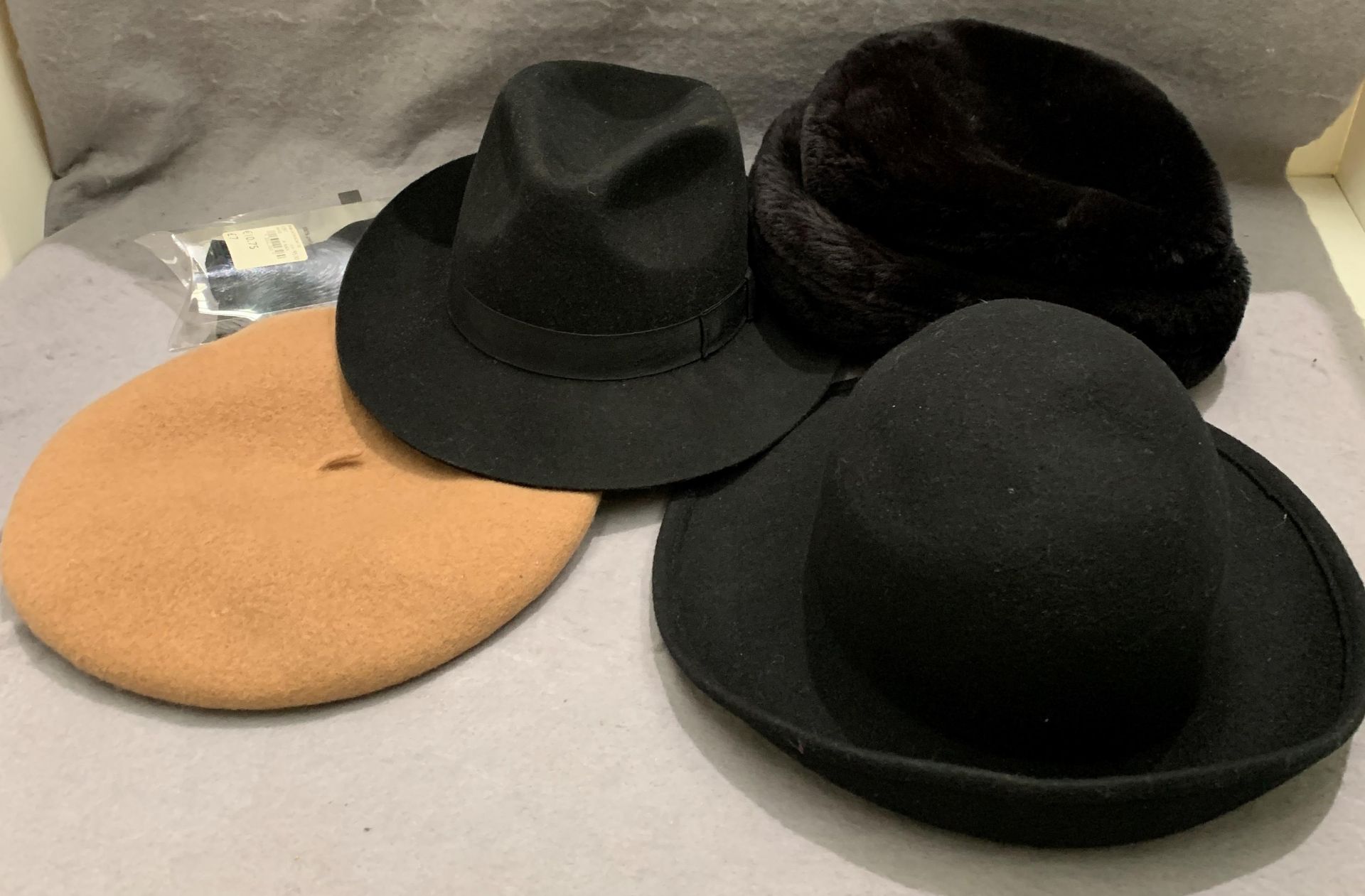 A black trilby by Christies, size 6 7/8, a fawn beret by Liz Claiborne, a black felt hat,