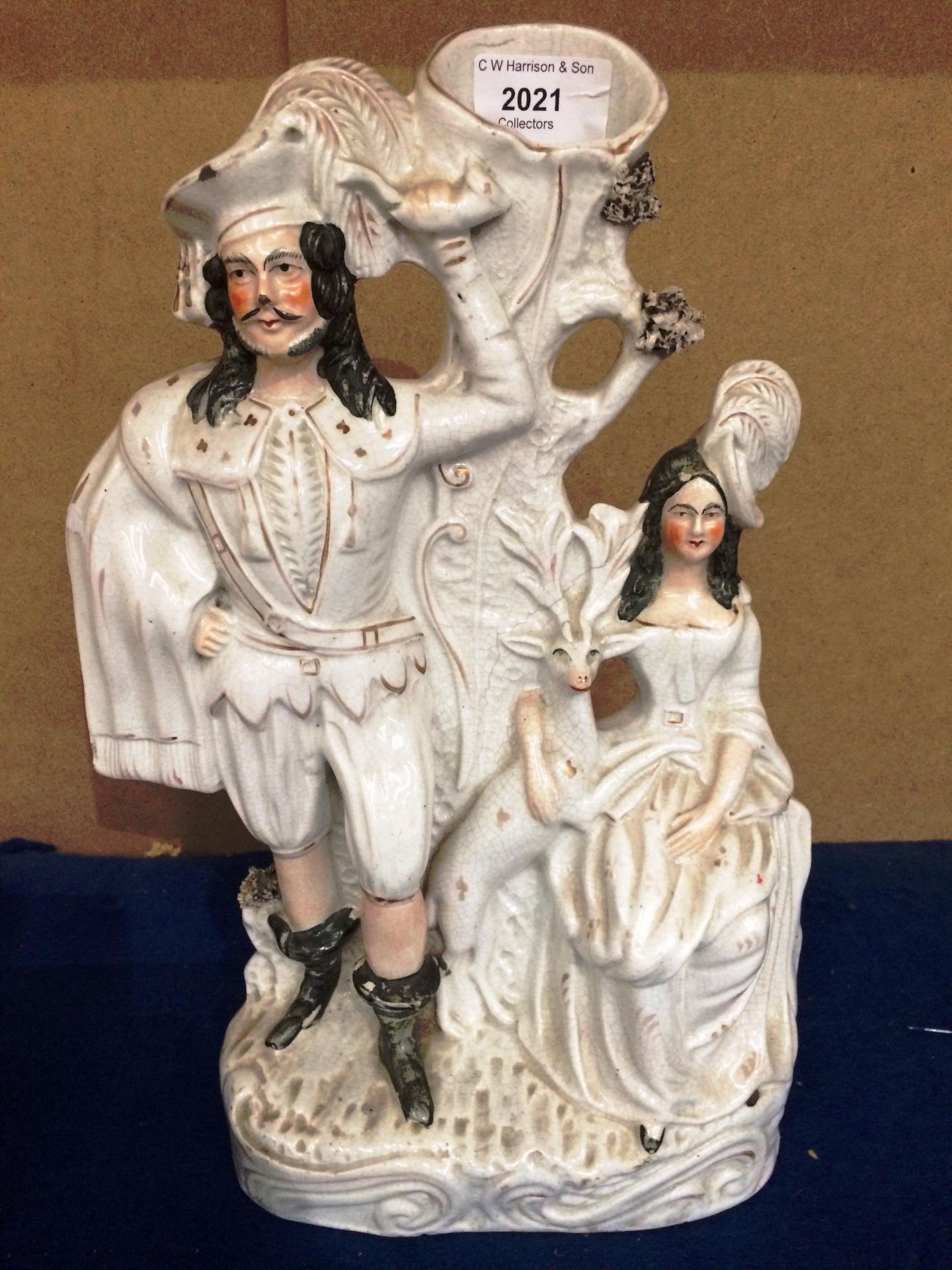 A Staffordshire style man and woman with deer figure group