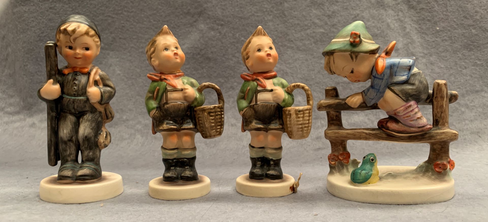 Four M J Hummel West Germany pottery figures - Boy on a Fence, 10cm, two boys with shopping baskets,