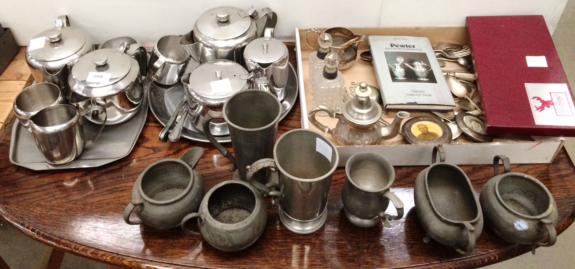 Contents to part table top two stainless steel tea services, pewter tankards and bowls,