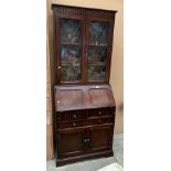 An oak bureau bookcase with two leaded glazed upper doors over fall flap three drawer two door base