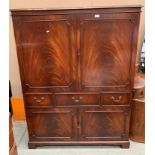 A large mahogany finish TV/entertainment cabinet - two upper doors over three drawers (one fall