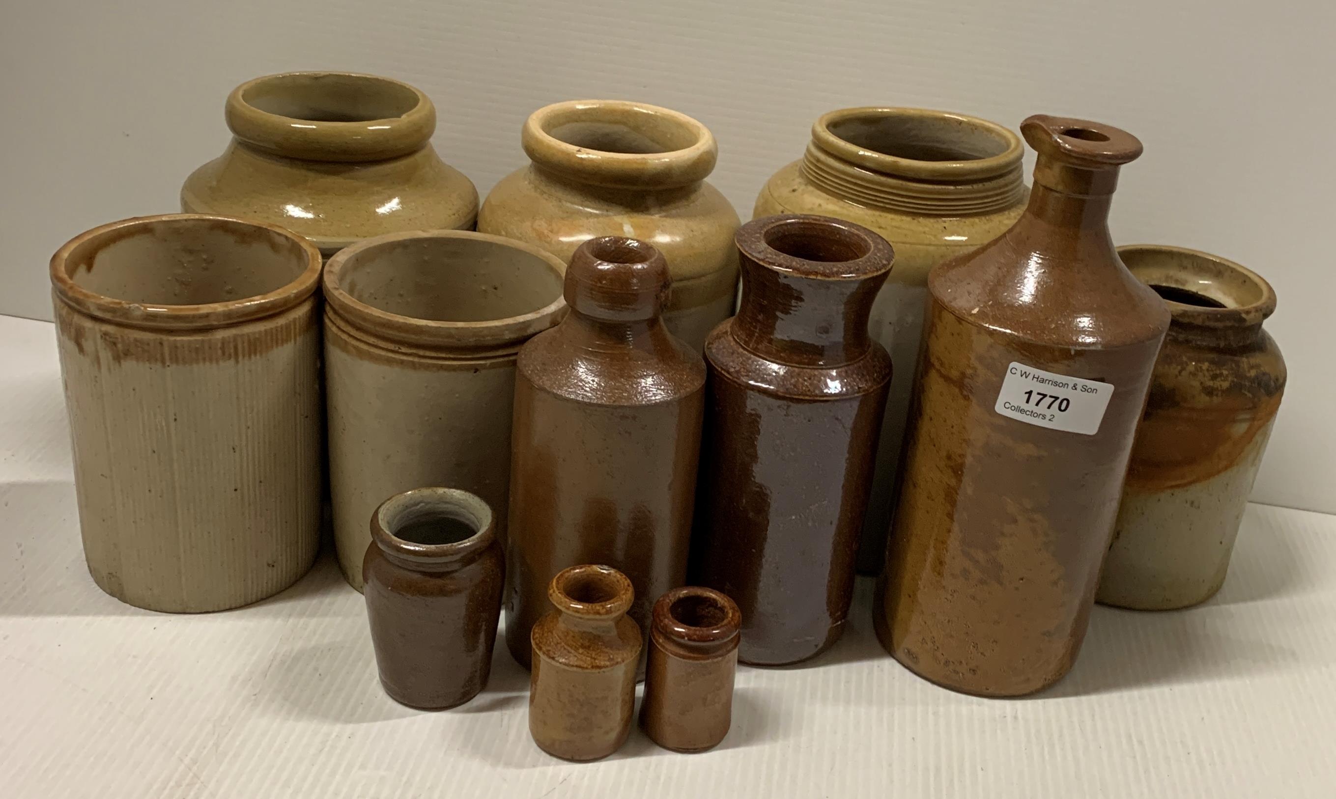 A collection of twelve various sized brown glazed stoneware storage jars and bottles