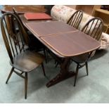 An Ercol dark elm dining table 150 x 75cm complete with heat resistant mats and four matching