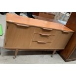 A teak three drawer two door sideboard 140cm on castors