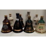Seven various Wade ceramic Bell's whisky decanters,
