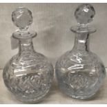 A pair of globular glass decanters with stoppers,