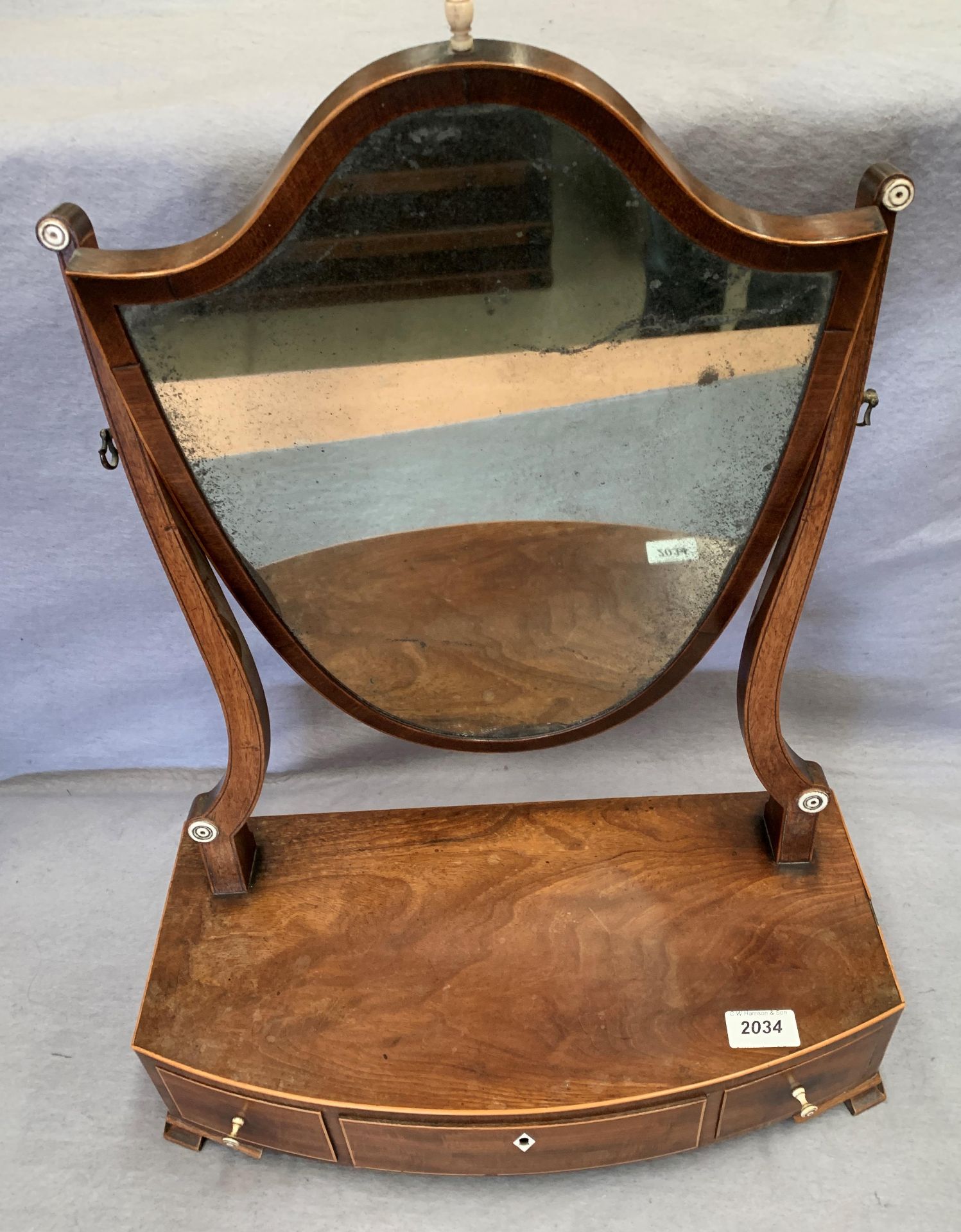 A mahogany shield shaped swing top toilet mirror with three under drawers