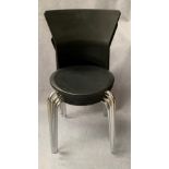 Four black plastic stacking chairs on chrome frames