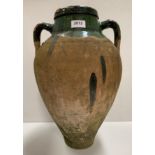 An old green painted and earthenware two handled olive jar 46cm high