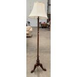 A mahogany standard lamp on tripod base complete with shade
