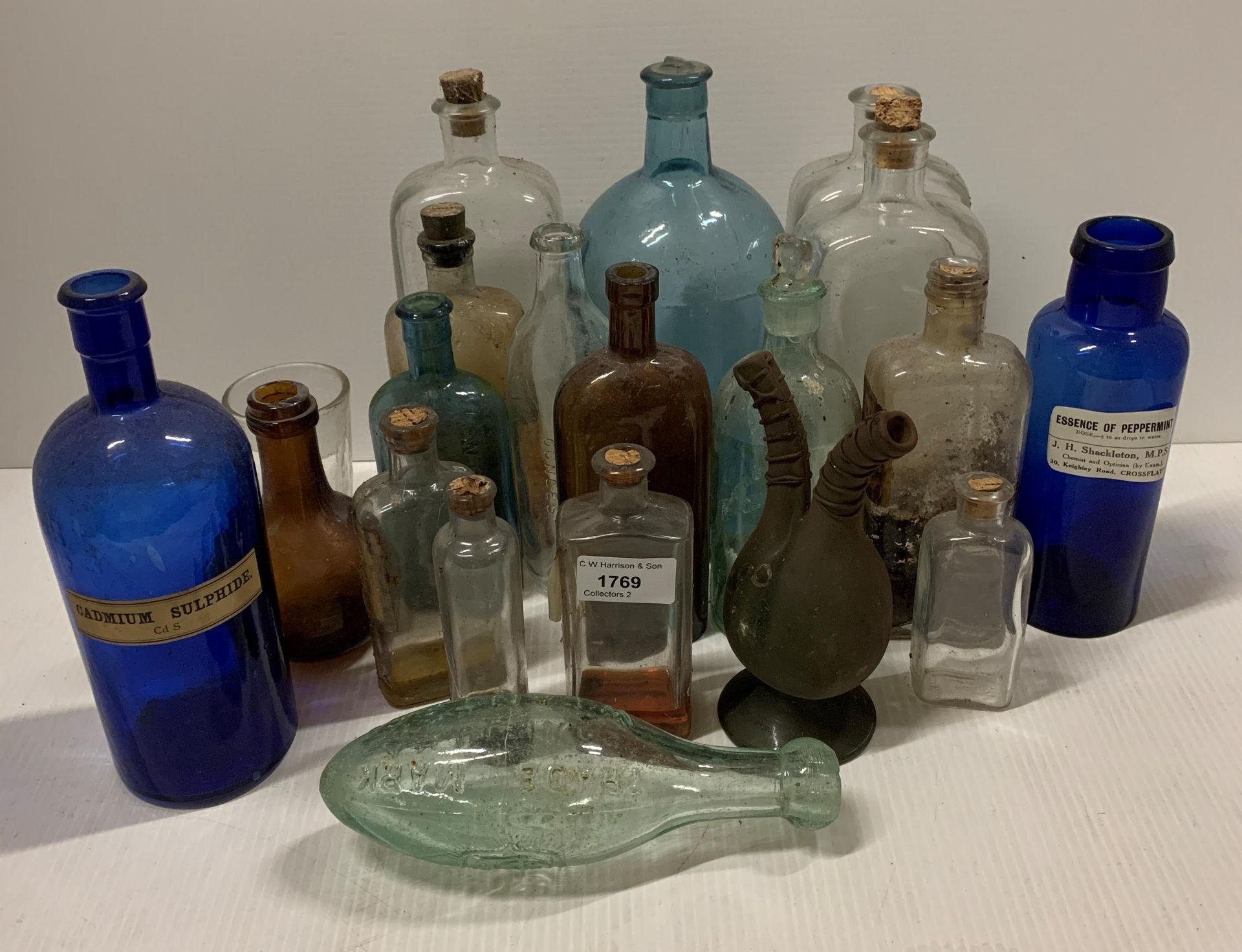 A collection of nineteen glass chemist and other bottles - some coloured,