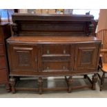 A 1930's carved oak two door two drawer shaped front sideboard with panel back 157 x 136cm high