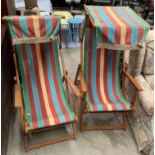 Two vintage wood framed deck chairs with striped seats and canopies