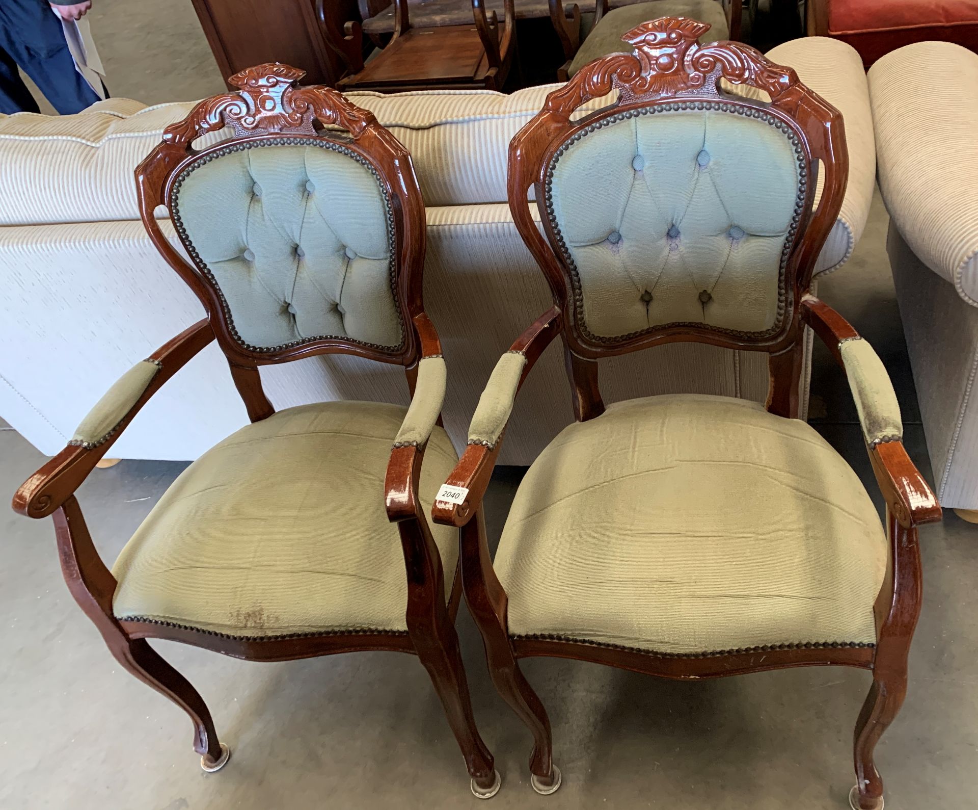 A pair of Continental style medium wood finish armchairs with light green buttoned back back pad