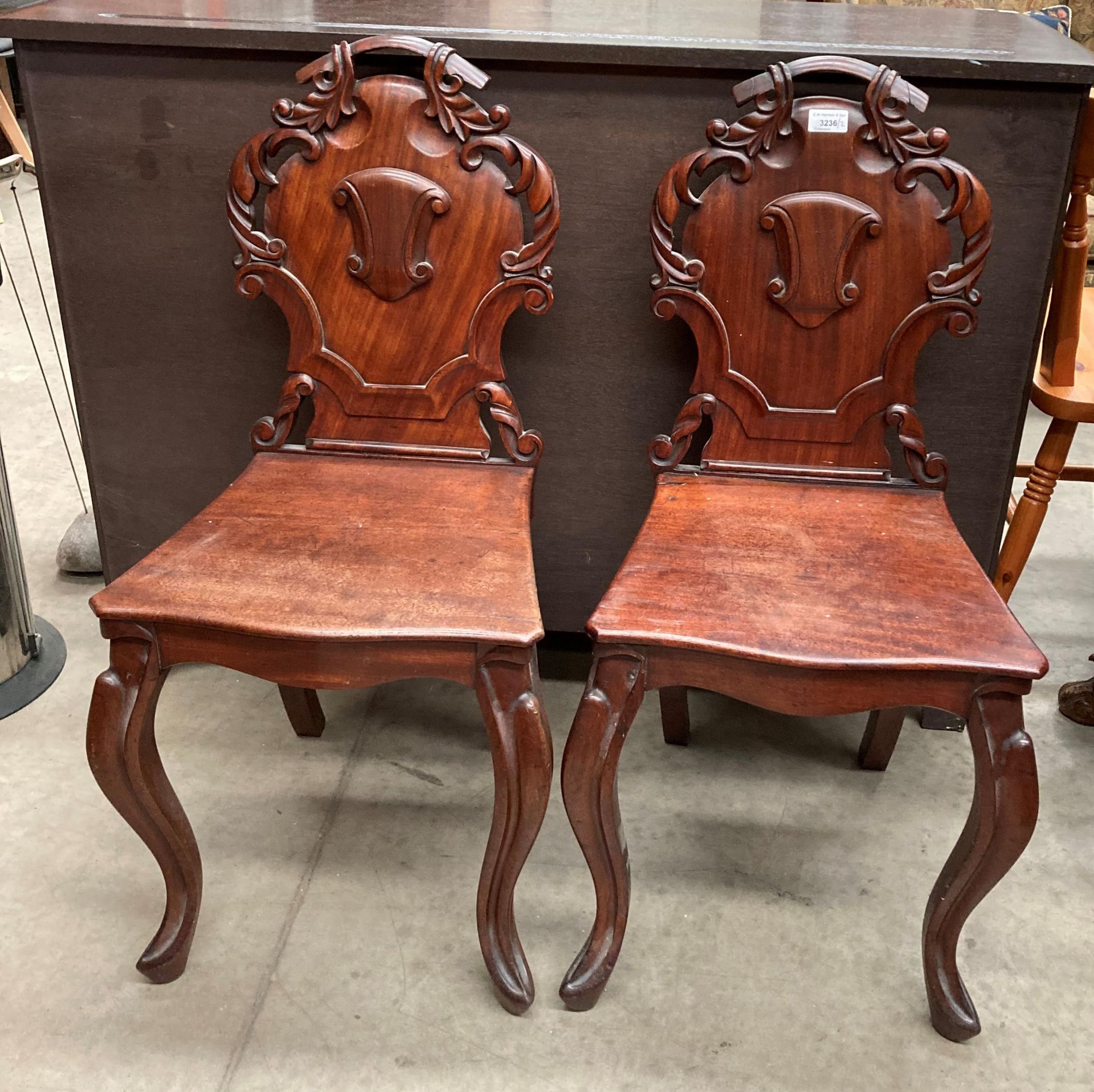 A pair of Victorian mahogany carved back hall chairs