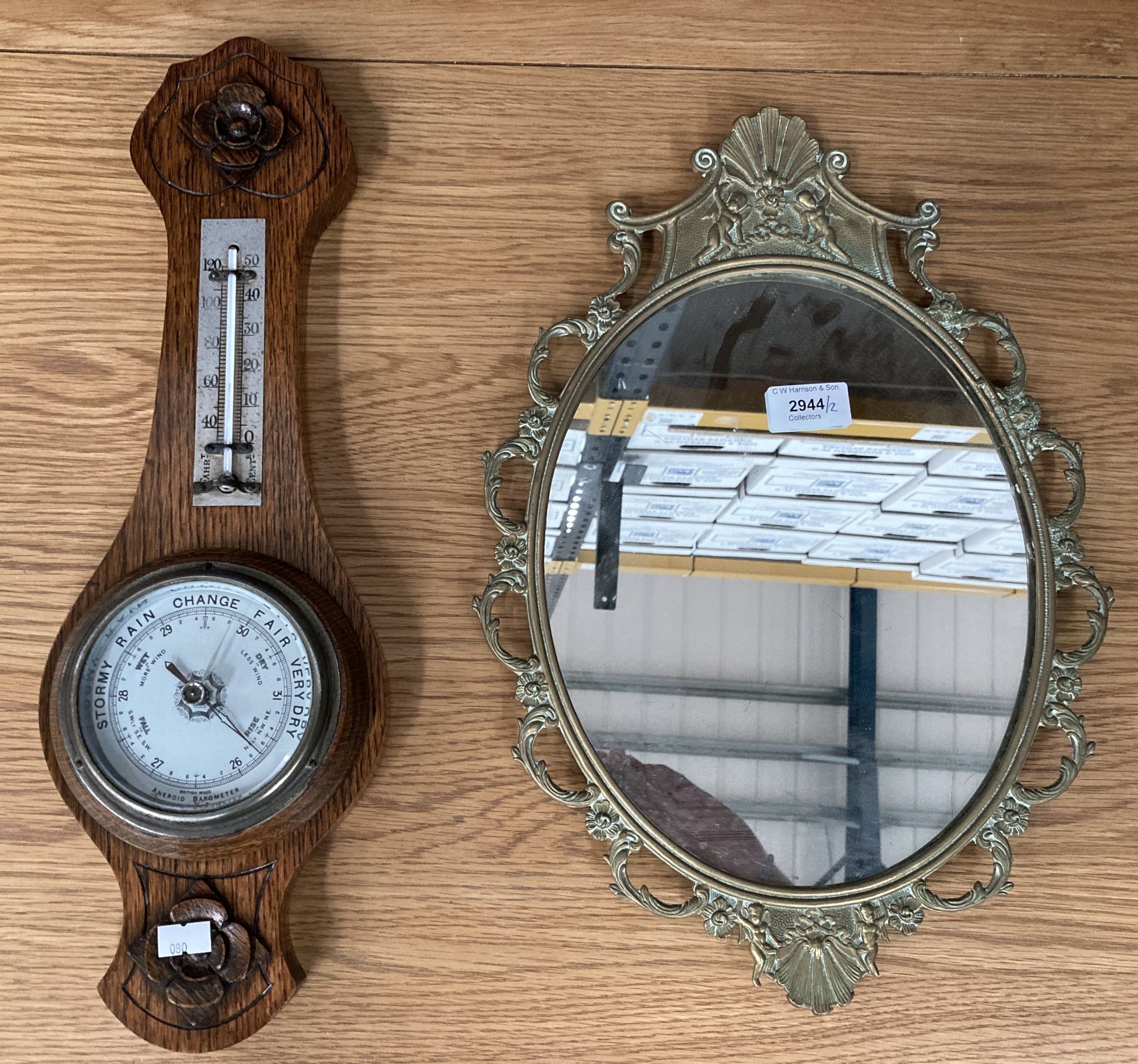 A small oak framed Aneroid wall barometer 46cm and a brass framed oval wall mirror 40cm x 28cm