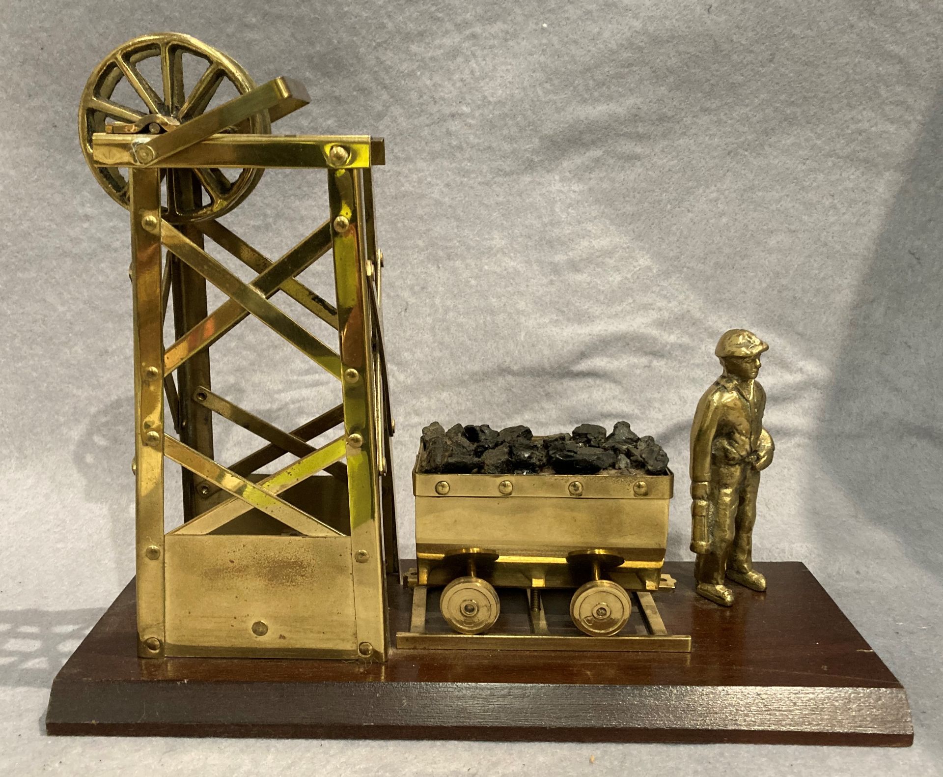 A brass mining model featuring a miner,