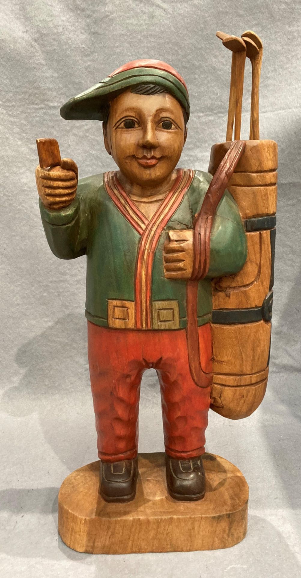 A painted wood statue of a golfer 52cm high