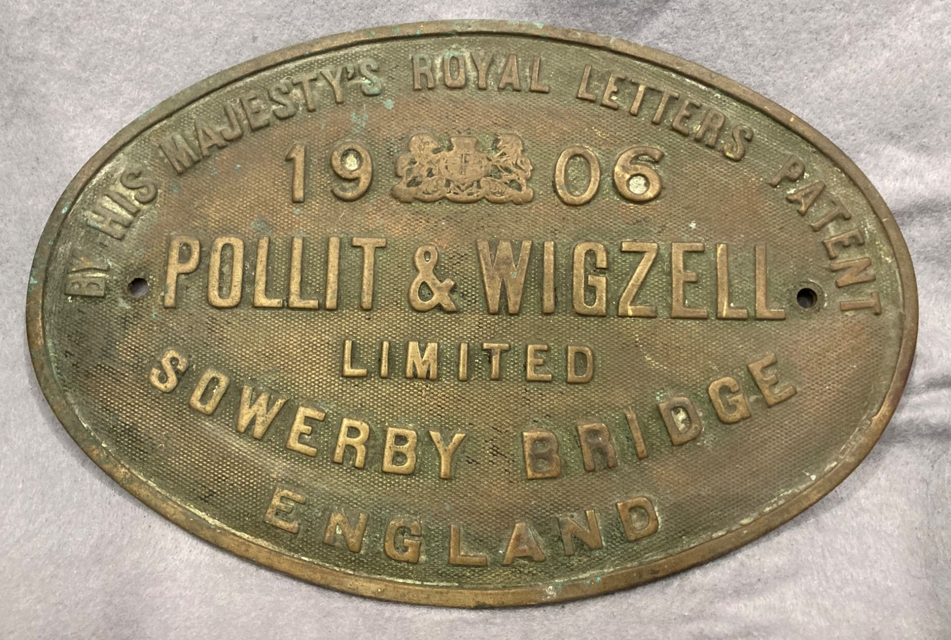An oval brass sign for Pollit and Wigzell Ltd, Sowerby Bridge, England,
