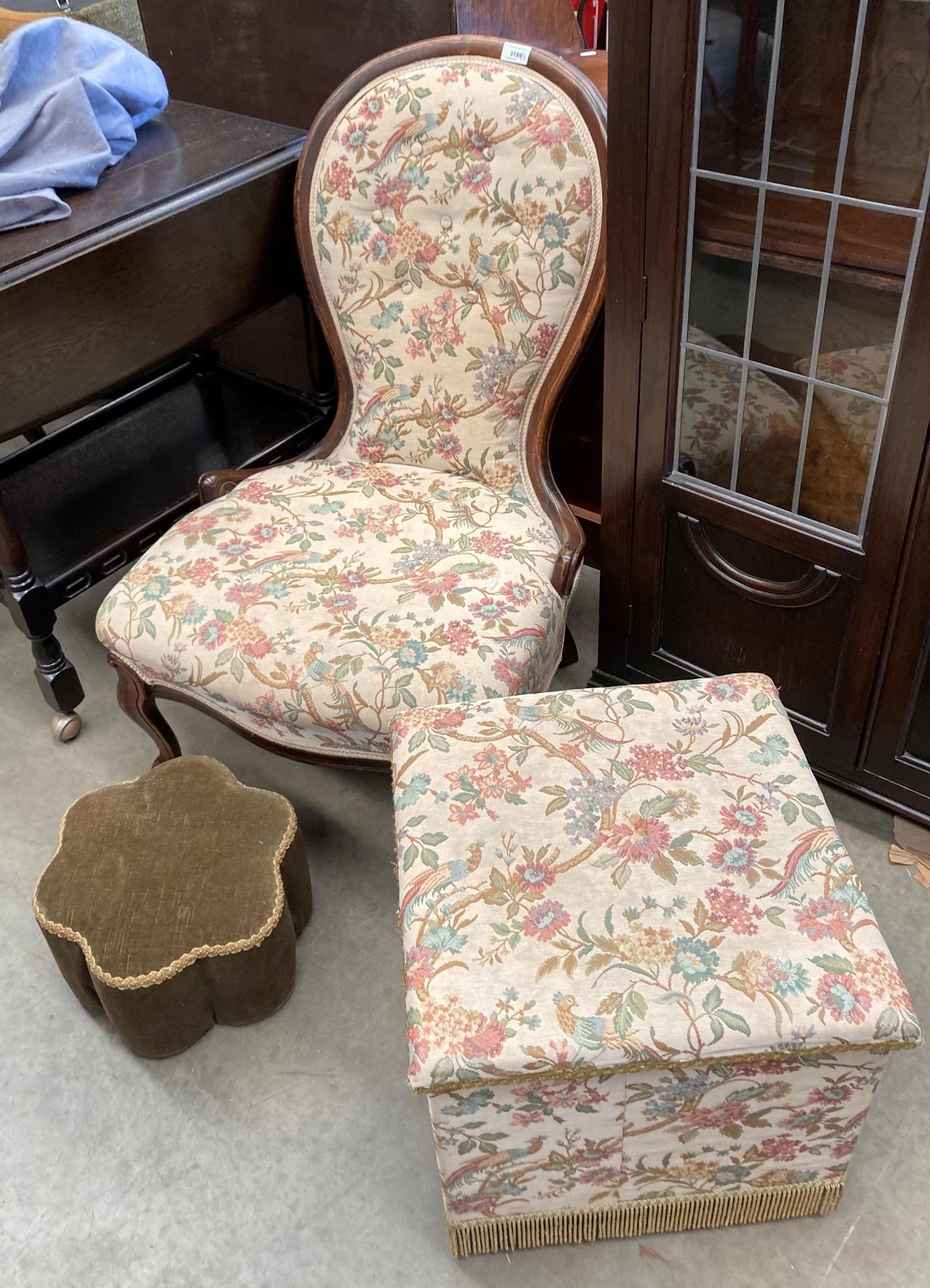 A stained mahogany balloon back nursing chair with yellow floral and bird patterned upholstery