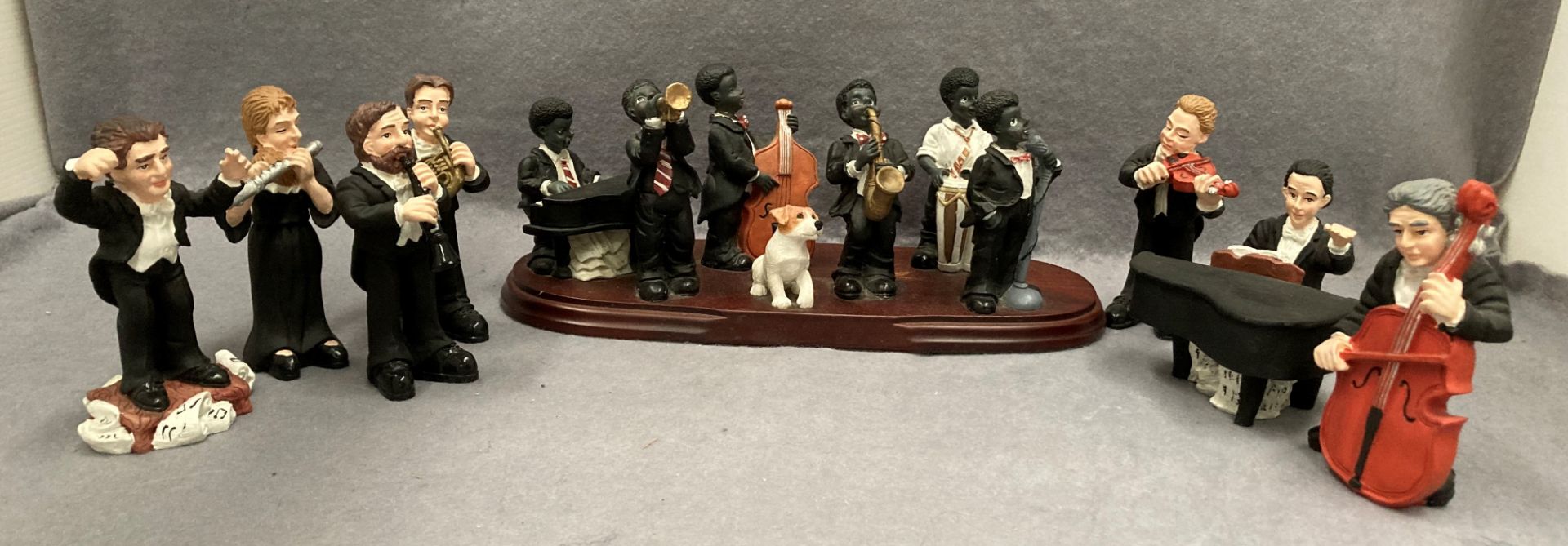 A resin six piece jazz band with dog on a wood plinth and seven resin bandsmen