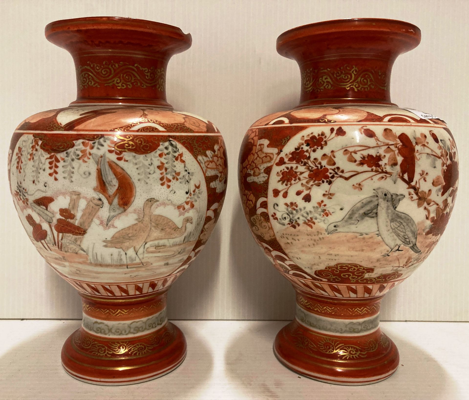 Pair of Oriental orange patterned vases each 23cm high (both with damages to rim)