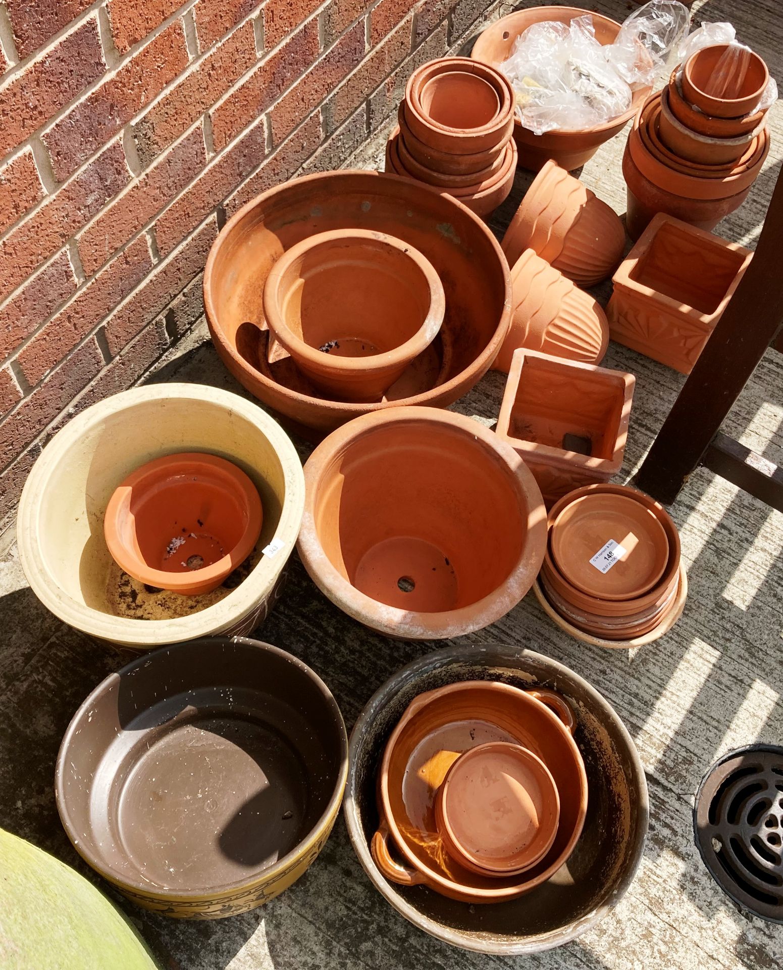 A large quantity of assorted terracotta and other plant pots, plant pot stands,