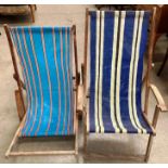 Two wood framed folding deck chairs with striped material seats