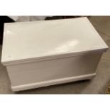 A white painted lift top storage chest on castors 87 x 52 x 44cm high