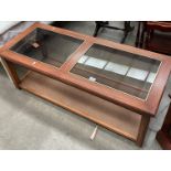 A medium wood finish coffee table with glass top and woven under tray 120 x 50cm