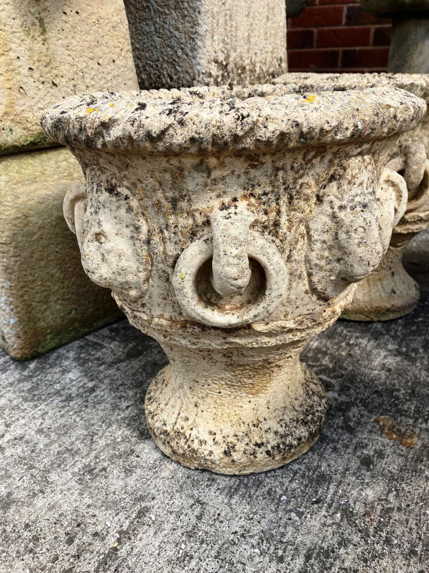 A pair of composition and concrete garden urns each 28cm high