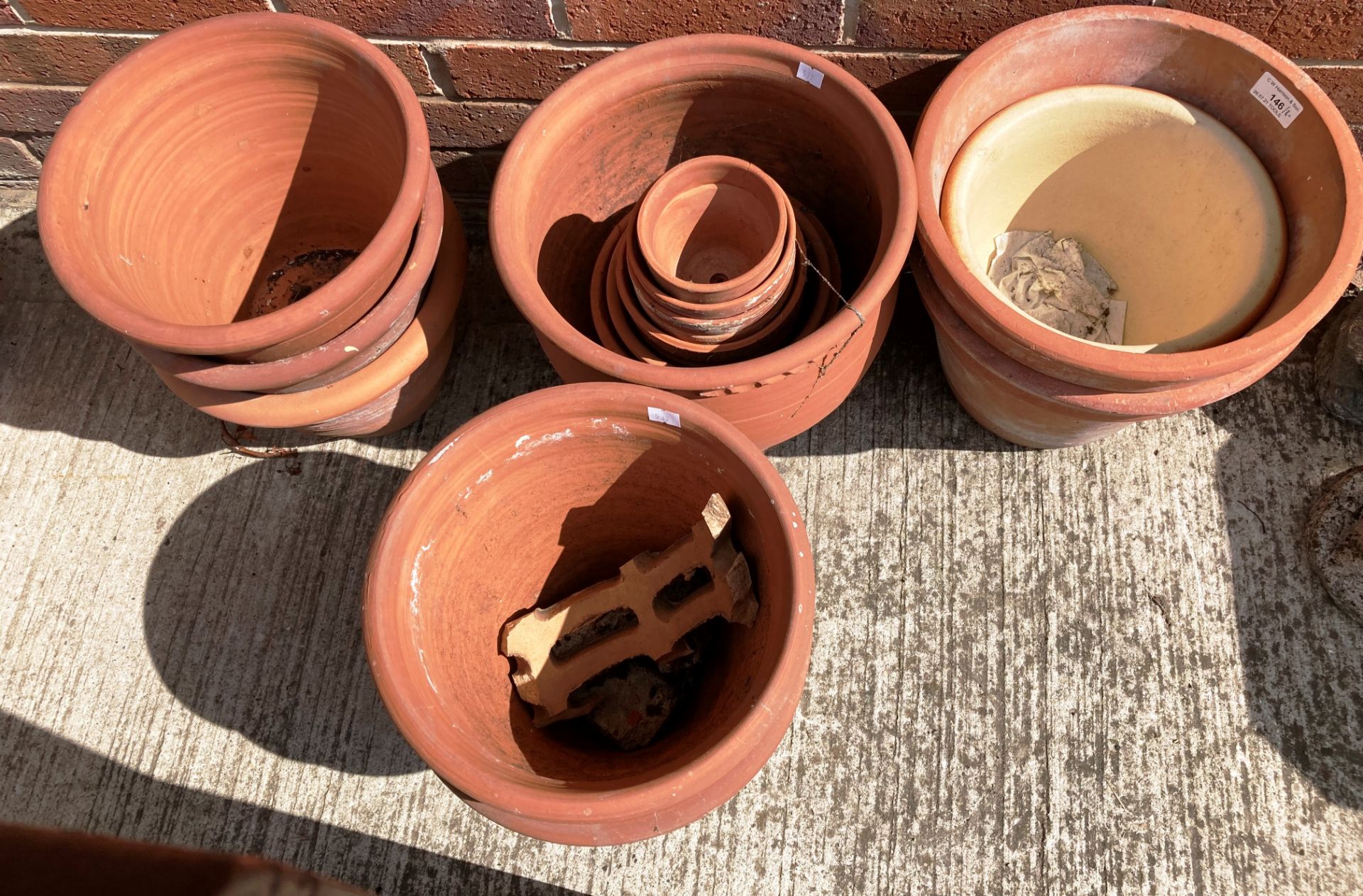 Eight large terracotta plant pots and a quantity of smaller terracotta plant pots