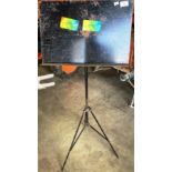 A black metal music stand with folding tripod base