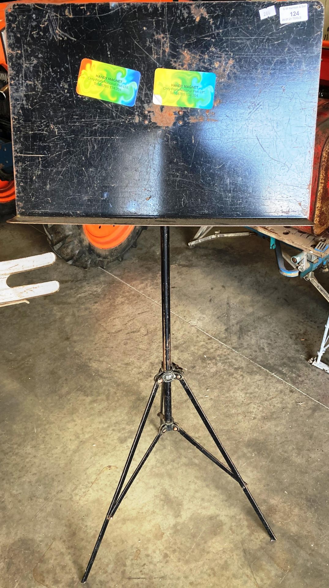 A black metal music stand with folding tripod base