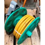 A Hozelock hose reel dispenser and small yellow hosepipe