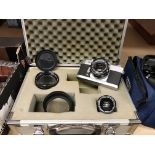 A Hakuba aluminium flight/camera case containing a Canon EXEE film camera and three lenses - as