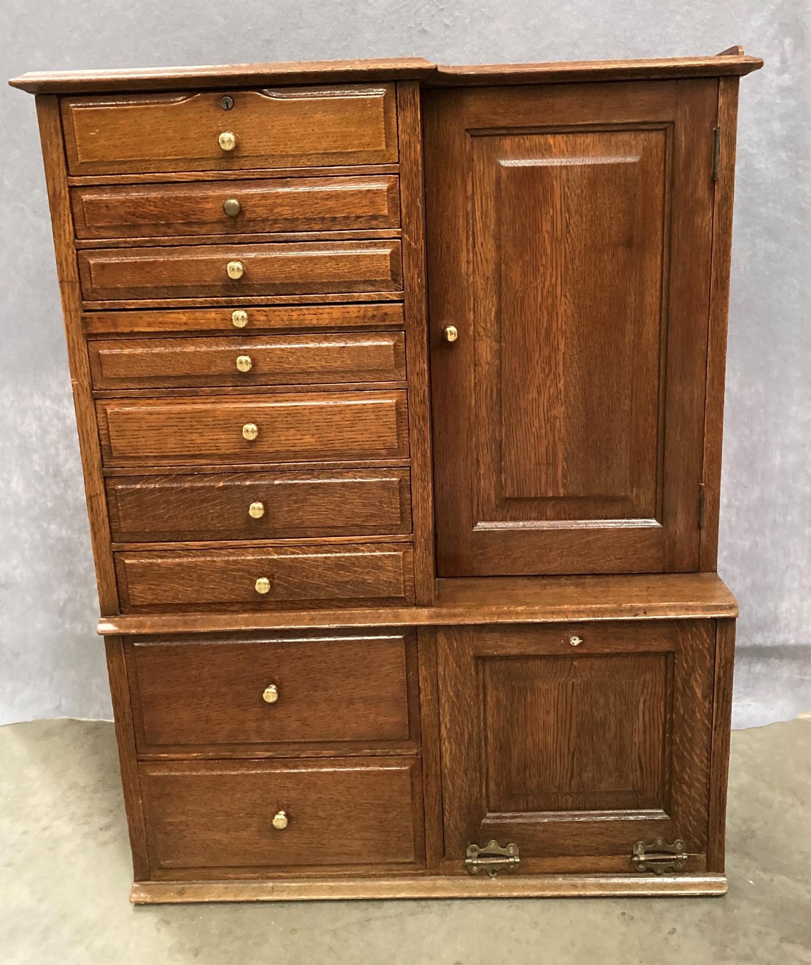 AN OAK TABLE TOP DENTAL CABINET with ten various sized drawers with brass handles and a recessed