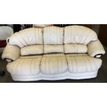 An Italian cream leather three piece suite with wood trim comprising a three seater settee and two