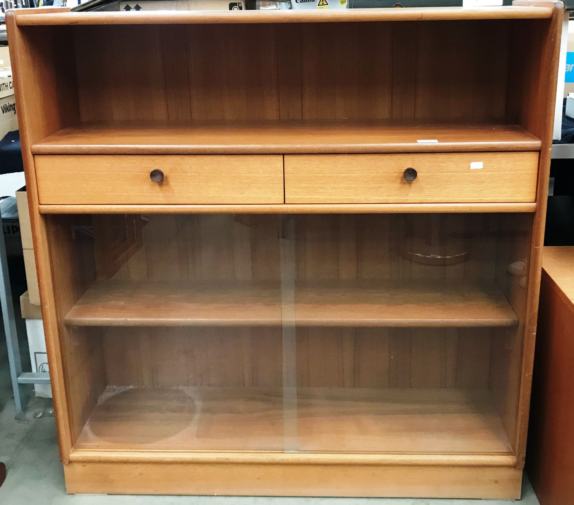 A Parker Knoll teak bookcase/side cabinet with open shelf over two drawers and glass sliding doors
